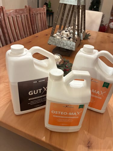 Customer's large Gut X jug on a wooden table with two other supplement jugs from the same brand.