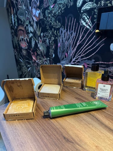 Customer's Harmony Routine products, including cleansers, a tube, and bottles, arranged on a wooden surface.