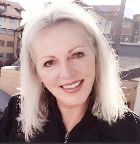 Reviewer with smooth, healthy skin smiling outdoors, showing results of the Anti-Aging Formula.