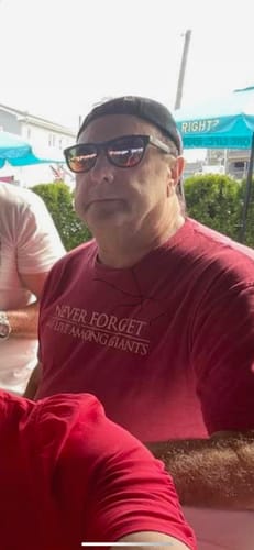 Close-up of a reviewer outdoors wearing a red TVP t-shirt that says 'Never Forget We Live Among Giants'.