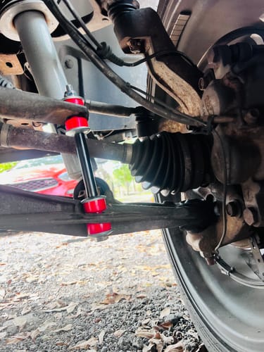 Customer's KSP Front Stabilizer Sway Bar Link with red bushings installed on a truck's suspension.
