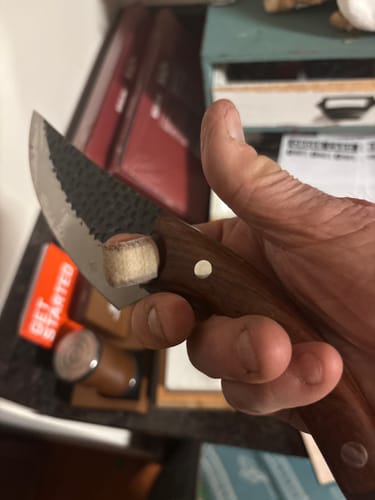 Customer holding a Tusk Knife, in a close-up showing the textured blade and wooden handle.