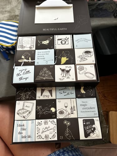 Customer's open Advent Calendar, showing the 24 individually illustrated drawers in black, white, and blue.