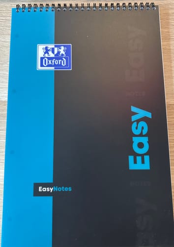 Le bloc à spirales EASYNOTES OXFORD d'un client, avec sa couverture bleue et noire, posé à plat sur une table.