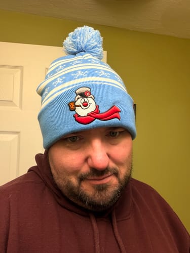 Reviewer wearing the light blue Frosty the Snowman pom-pom beanie.