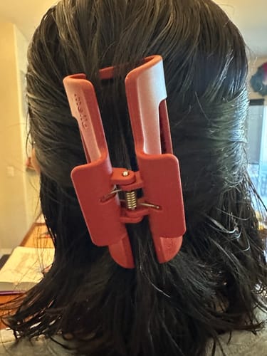 Customer showing the back of the red cloud clip holding their short, dark hair.
