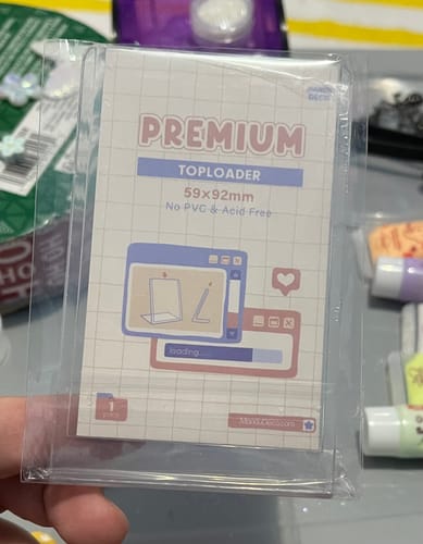 Customer holding a Standing Toploader in its original clear packaging, showing the front insert.