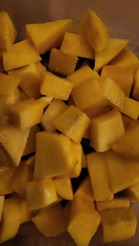 Rezensent zeigt eine Nahaufnahme von gewürfelten, cremigen Riesenmangos.