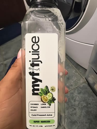 Customer holds a nearly empty bottle of My Fit Juice, showing the 'Super Squeezed' label.