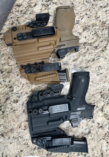 Customer's side-by-side view of a tan and a black AXIS ELITE holster, each holding a pistol and spare magazine.