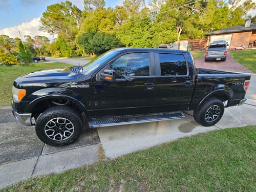 Customer's clean black truck with a shiny finish parked on a residential driveway.