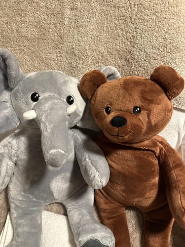 Recensent toont de grijze Olifant en bruine Beer verzwaringsknuffels die samen op een deken liggen.