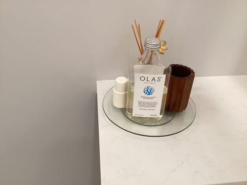Reviewer's OLAS Mouthrinse glass bottle displayed as a stylish diffuser on a white countertop.