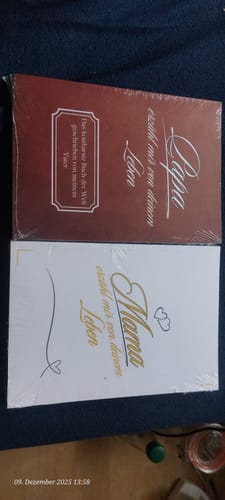 Rezensent zeigt die eingeschweißten Bücher: das weiße 'Mama, erzähl mir von deinem Leben' und die braune 'Papa'-Version.