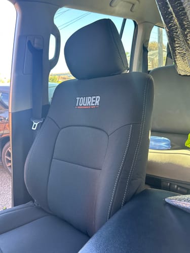 Customer's stylish GP9 Tourer front seat cover installed in a Toyota Landcruiser, showing its snug fit and embroidered logo.