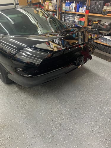 Customer's black Strutless Drag Wing with an adjustable wicker installed on the back of a Camaro in a garage.