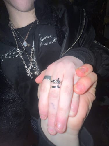 Close-up of a customer wearing the DEATH KNIGHT SWORD RING on their finger while holding another person's hand.