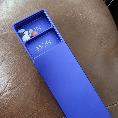 Reviewer's indigo Weekly Case, open to show pills in the Monday compartment.