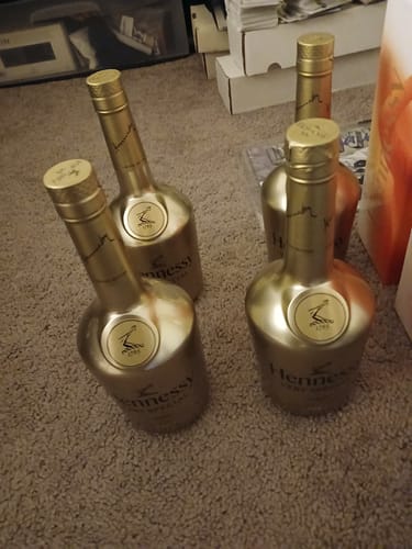 Customer's four bottles of Hennessy V.S. 1765 Cognac Gold Limited Edition standing on a carpeted floor.