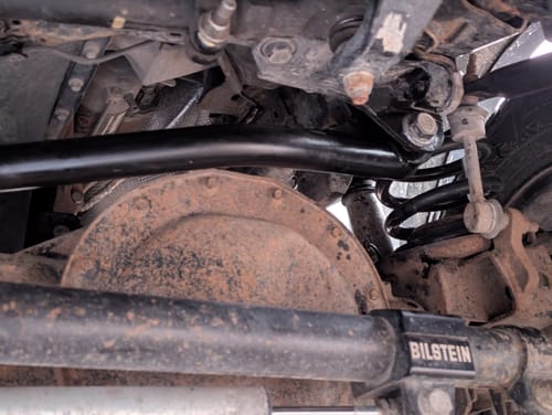 Customer's solid black Front Adjustable Track Bar installed on the undercarriage of their truck, showing its sturdy build.