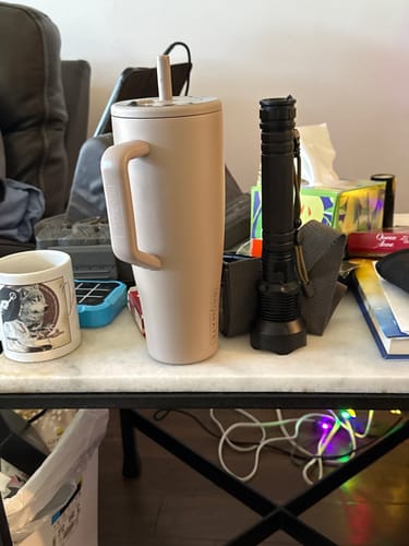 Customer's Mocha 40oz Era Tumbler with its straw, shown on a marble-top table in a room.