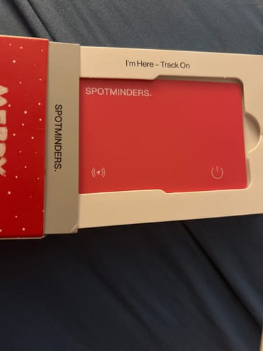 Customer showing the red SPOTMINDERS Tracking Card partially removed from its packaging.
