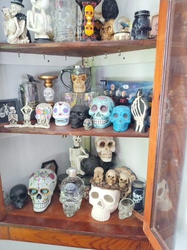 Reviewer's Crystal Head Vodka bottle displayed on a shelf as part of a large collection of skull-themed decor.