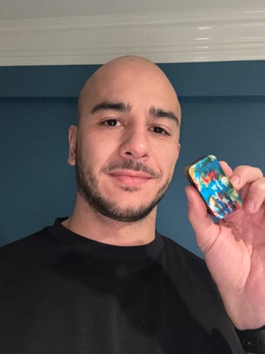 Reviewer holding a small, colorful pill container from the 3-Pack Bundle in their hand.