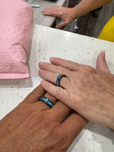 Customer review showing two hands wearing their matching Titanium Carbide Rings with Cremation Ashes.