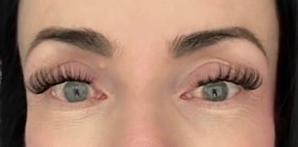 Nahaufnahme der Augen einer Rezensentin, die die vollen und geschwungenen Say Less Wimpern trägt.