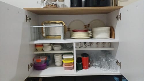 Müşterinin Rani çok amaçlı dolabının içi; tabaklar, kaseler, bardaklar ve saklama kapları gibi mutfak eşyalarıyla dolu.