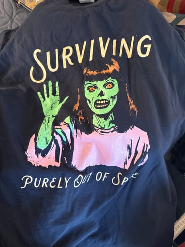 Customer's dark blue 'Surviving Purely Out Of Spite' tee showing the vibrant graphic of a waving zombie.