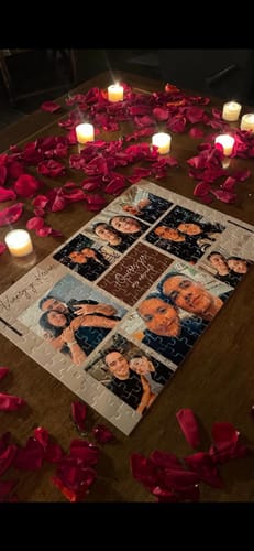 Cliente muestra su rompecabezas personalizable completado sobre una mesa con pétalos de rosa y velas encendidas.