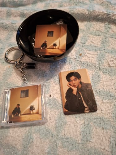 Customer's BTS FESTA capsule album contents, showing the black capsule, a mini album keychain, and one photocard.
