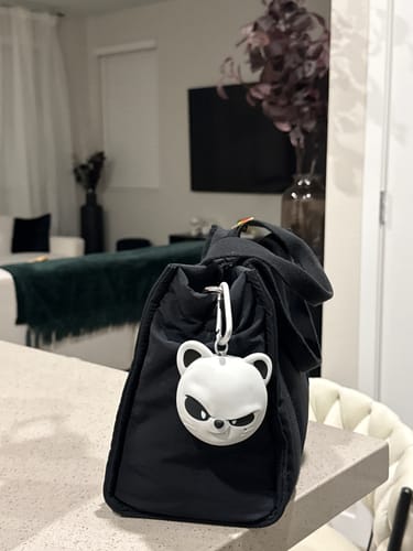 Customer's white Evil SKZOO speaker clipped to a black bag on a countertop.