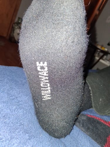 Close-up of the sole of a customer's dark, pilled Men's Alpaca Sock.