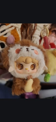 Customer's close-up of a Yooki Hug vinyl plush figure wearing a fluffy brown and white costume with a hood.
