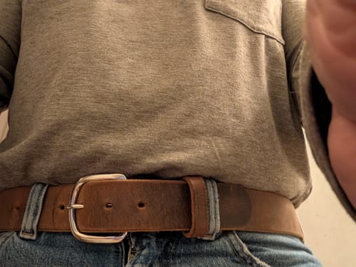Reviewer's close-up photo of the brown Crazy Horse leather belt worn with jeans.