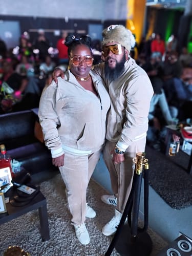 Customer and a partner in matching Viaggioa Track Pant outfits, styled for an 80's hip-hop party.