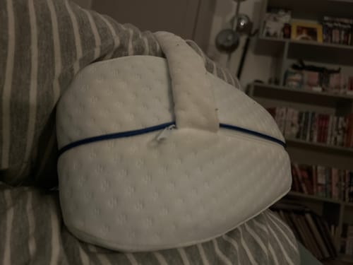 Coussin orthopédique pour genoux Cellsius d'un client, blanc et texturé, utilisé entre les jambes.