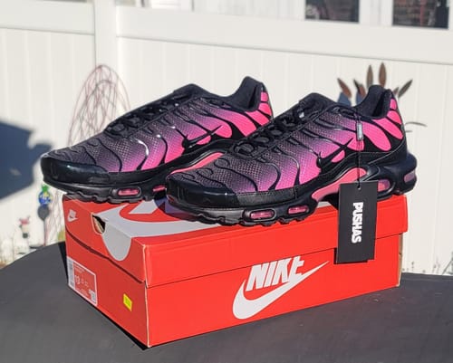 Customer's pair of Nike Air Max Plus TN 'Black Hyper Pink' sneakers displayed on the red Nike shoebox outdoors.
