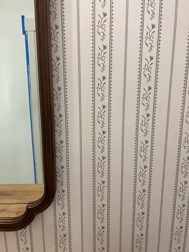 Customer's close-up of the Shayne Wallpaper, showing the striped floral pattern on a bathroom wall next to a mirror.