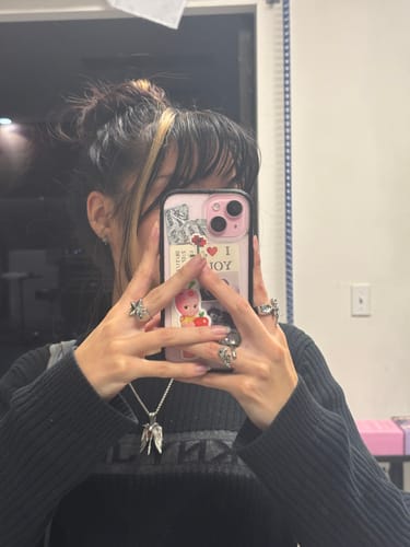 Customer showing their hand with the stylish Star Ring on the index finger, worn with other rings.