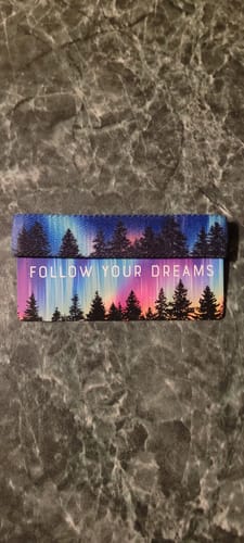 Customer's Follow Your Dreams Bracelet showing its reversible sides with a colorful aurora over a treeline.