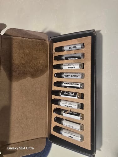 Recensore mostra il set di campioni di profumo aperto, con una macchia di liquido all'interno della scatola di spedizione.