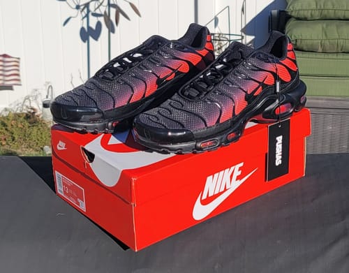 Customer's Nike Air Max Plus TN 'Black Light Crimson' sneakers displayed on their red Nike shoebox.