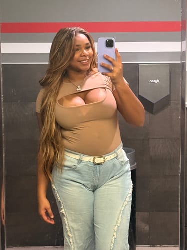 Reviewer taking a mirror selfie wearing the long, wavy Outre Perfect Hairline On Vybes wig.