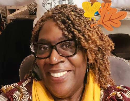 Reviewer smiling while wearing the brown, twisted Nutique Illuze YANKY TWIST 14" wig.