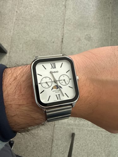 Usuario mostrando en primer plano su reloj Casio Moonphase con correa de acero en la muñeca.