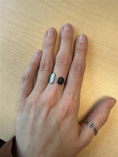 Reviewer wearing the adjustable Aquamarine Wrap Ring on their middle finger, showing it fits well on their enlarged knuckle.